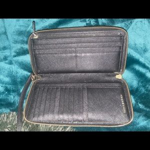 Tory Burch black wallet with gold tone zipper.